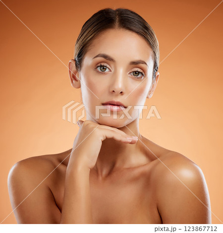 Face, beauty skincare and portrait of woman isolated on an orange studio background. Makeup, model and female from Canada with glowing skin, healthy skin or flawless skin after facial spa treatment. 123867712