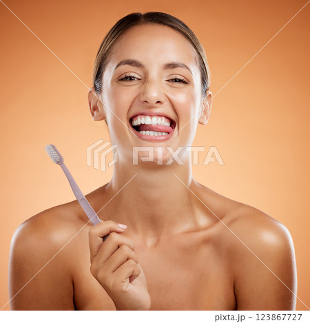 Brushing teeth, woman skincare and dental portrait wellness, health and cleaning cosmetics on orange studio background. Happy young model funny face, tongue mouth and toothpaste, toothbrush and smile 123867727