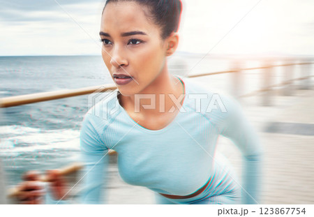 Fast, fitness and woman running in nature for cardio health, wellness and sports motivation by the ocean. Face of an athlete runner with speed, training and doing a workout for exercise by the sea Fast, fitness and woman running in nature for cardio health, wellness and sports motivation by the ocean. Face of an athlete runner with speed, training and doing a workout for exercise by the sea 123867754
