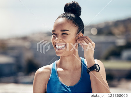 Fitness, happy and woman with earphones for music entertainment with wireless technology on workout rest. Exercise, training and wellness girl in city with smile streaming audio podcast on break 123868066