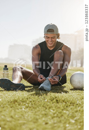 Fitness, grass and man tie shoes on grass for football training, workout and sports exercise. Summer, energy and health with athlete with sneakers in city park for lifestyle, wellness and soccer ball 123868337