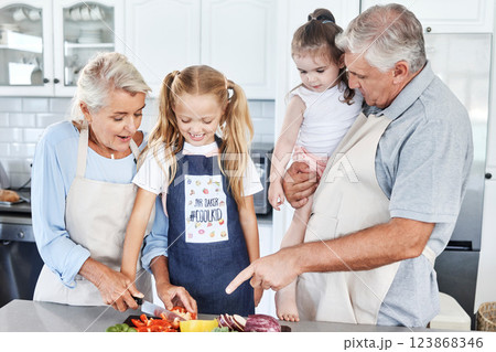 Cooking, smile and grandparents teaching children to cook food together in the kitchen of their house. Happy and young kids learning and helping an elderly man and woman with healthy lunch or dinner 123868346