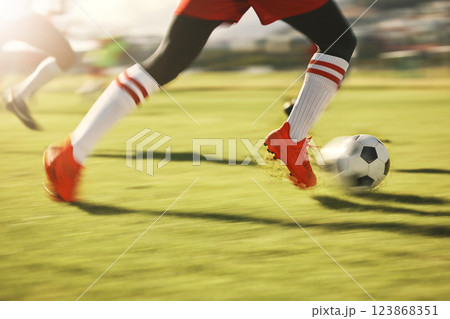 Soccer, sports and running with the shoes of a man athlete on a grass pitch or field during a game. Football, fitness and training with a male player dribbling during a match or cardio workout 123868351