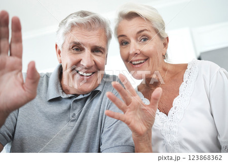 Senior couple, wave and home video call, talking or speaking or discussion. Retirement, happy elderly man and woman greeting on online, web or internet video conference in house together with smile 123868362