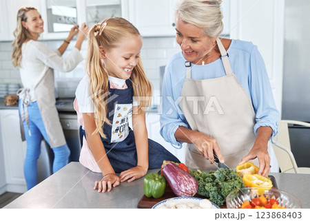 Learning, mother and grandmother cooking with girl teaching her a family recipe, vegetables and food diet. Smile, mom and senior woman love helping kid in the kitchen with child development at home 123868403