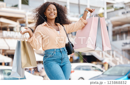 Shopping, fashion and retail, a black woman with smile and designer boutique shopping bags outside a mall. Happy customer or influencer after discount sale in city shopping mall parking lot or street Shopping, fashion and retail, a black woman with smile and designer boutique shopping bags outside a mall. Happy customer or influencer after discount sale in city shopping mall parking lot or street 123868832