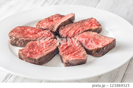 Perfectly sliced medium-rare fillet mignon steak served on a white plate 123869325