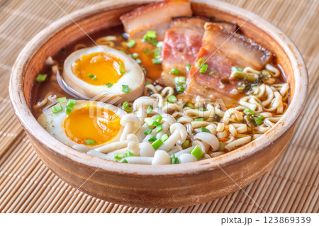 Hearty rustic ramen bowl with pork belly, beech mushrooms, and ramen eggs 123869339