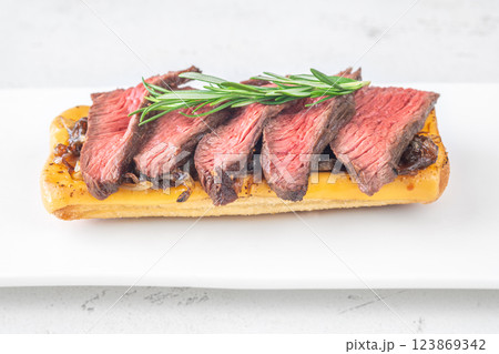 Grilled ciabatta sandwich with melted cheese, juicy steak, caramelized onions, and rosemary Grilled ciabatta sandwich with melted cheese, juicy steak, caramelized onions, and rosemary 123869342