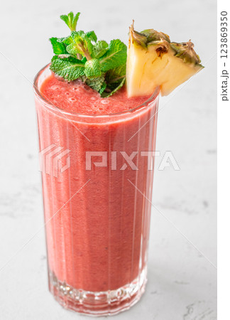 Fruit smoothie with cherry, banana, pineapple, mint garnish, and pineapple wedge Fruit smoothie with cherry, banana, pineapple, mint garnish, and pineapple wedge 123869350