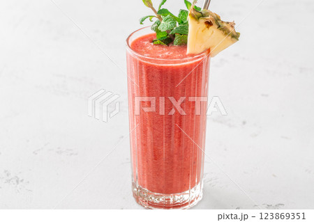 Fruit smoothie with cherry, banana, pineapple, mint garnish, and pineapple wedge Fruit smoothie with cherry, banana, pineapple, mint garnish, and pineapple wedge 123869351