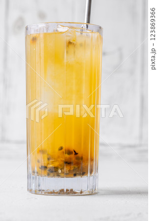 Passion Fruit Caipirinha cocktail in highball glass with straw on white wooden Passion Fruit Caipirinha cocktail in highball glass with straw on white wooden 123869366
