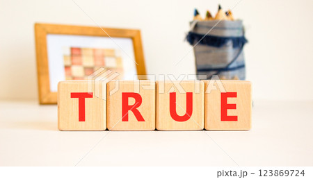 True symbol. Concept word True on beautiful wooden blocks. Beautiful picture frame and colored pencils. Beautiful white table white background. Business, lifestyle, support true concept. Copy space. True symbol. Concept word True on beautiful wooden blocks. Beautiful picture frame and colored pencils. Beautiful white table white background. Business, lifestyle, support true concept. Copy space. 123869724