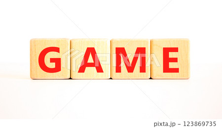 Game symbol. Concept word Game on beautiful wooden blocks. Beautiful white table white background. Business, lifestyle and game concept. Copy space. Game symbol. Concept word Game on beautiful wooden blocks. Beautiful white table white background. Business, lifestyle and game concept. Copy space. 123869735