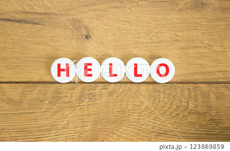 Hello symbol. Concept word Hello on beautiful white pills circles. Beautiful wooden table wooden background. Business lifestyle hello concept. Copy space. Hello symbol. Concept word Hello on beautiful white pills circles. Beautiful wooden table wooden background. Business lifestyle hello concept. Copy space. 123869859
