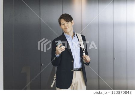 カメラ目線のスマートフォンを持った30代のビジネスマン カメラ目線のスマートフォンを持った30代のビジネスマン 123870848