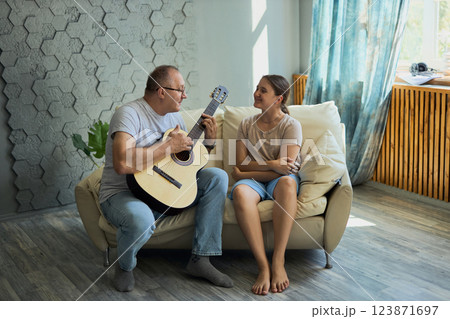 Grandfather and granddaughter sing and play guitar 123871697
