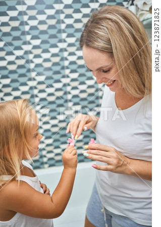 Young mother and daughter in curlers in a bathroom 123871825