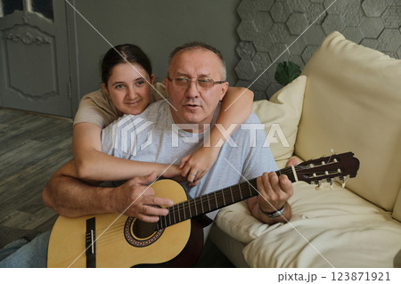 Grandfather and granddaughter sing and play guitar Grandfather and granddaughter sing and play guitar 123871921
