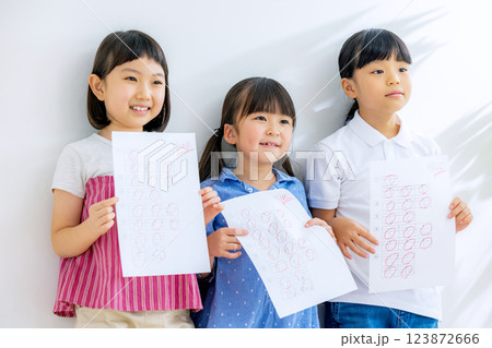 100点の答案用紙を持つ子どもと先生 100点の答案用紙を持つ子どもと先生 123872666