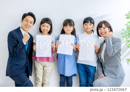 100点の答案用紙を持つ子どもと先生 100点の答案用紙を持つ子どもと先生 123872667