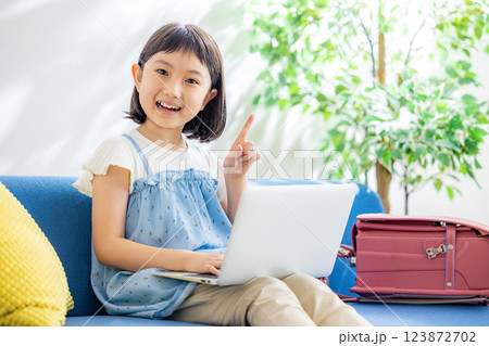 リビングでパソコンを使う小学生の児童 123872702