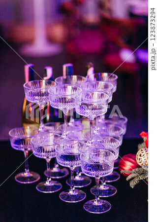 A pyramid of wide champagne glasses on deep blue tablecloth at event A pyramid of wide champagne glasses on deep blue tablecloth at event 123873294