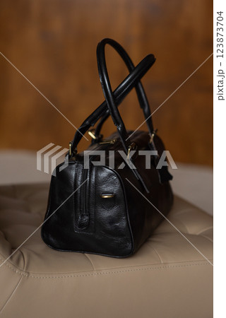 Black leather travel bag on a chair Black leather travel bag on a chair 123873704