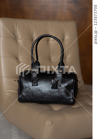 Black leather travel bag on a chair 123873708
