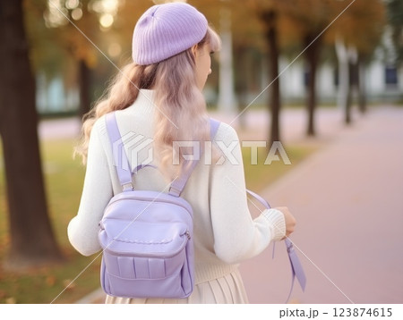 A student with a violet lavender backpack in school uniform, walking on a campus outdoors, seen from behind. A high school or university teenager girl. Casual teen outfit fashion. Light purple shades 123874615