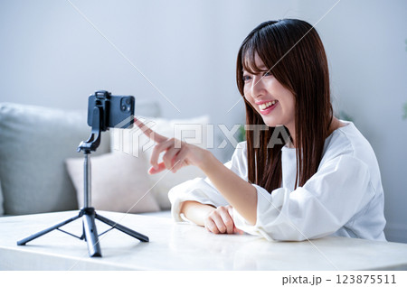 動画撮影中スマホに指をさす女性 123875511