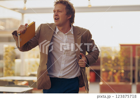 A businessman in a hurry is navigating through a modern workspace filled with opportunities 123875718