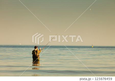 Man standing in water doing extreme fishing 123876459