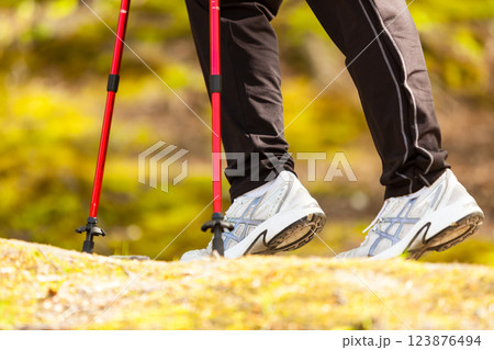 Nordic walking. Female legs hiking in forest or park. 123876494