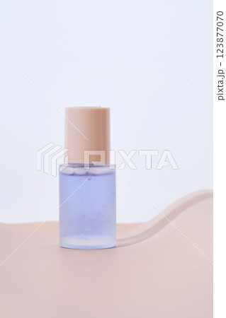 A bottle of blue serum on a delicate beige background. A bottle of blue serum on a delicate beige background. 123877070