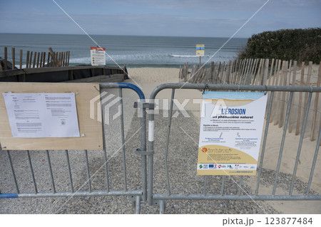 Warning signs indicate coastal erosion at Biscarosse shoreline with restricted access to beach area 123877484