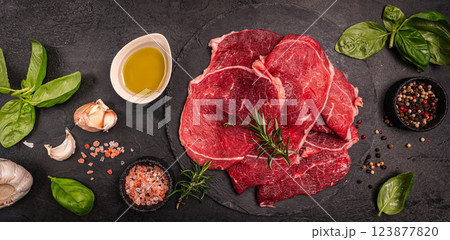 Raw organic steak with ingredients for cooking Raw organic steak with ingredients for cooking 123877820