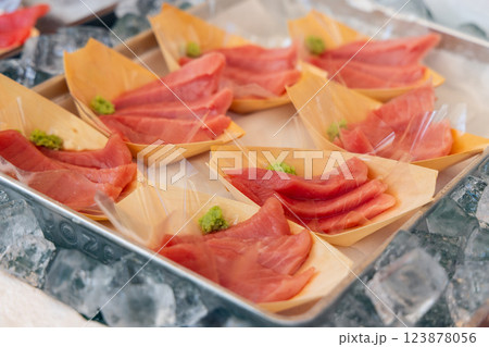 Thinly sliced tuna sashimi is served in wooden trays with wasabi Thinly sliced tuna sashimi is served in wooden trays with wasabi 123878056