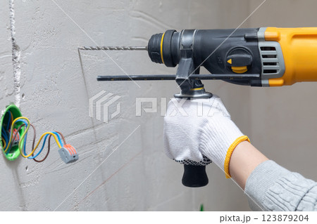Perforating machine drilling the wall. Perforating machine drilling the wall. 123879204