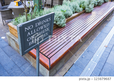 Close up of a - No Drinks Allowed on These Benches - sign in an urban seating area 123879687