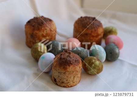 Easter cakes and colorful Easter eggs on a white tablecloth Easter cakes and colorful Easter eggs on a white tablecloth 123879731