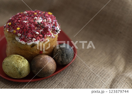 Easter cake with three Easter eggs in a red plate on the table Easter cake with three Easter eggs in a red plate on the table 123879744