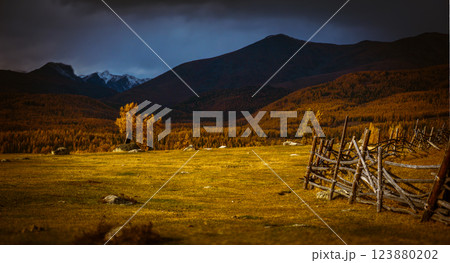Rustic wooden fence on a hilly autumn countryside landscape with distant mountains 123880202