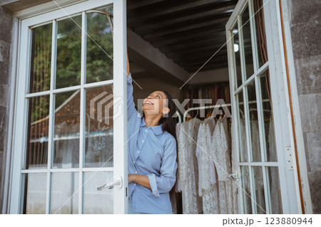 Contemplative Moment: Woman Reaching for the Sky in a Beautiful Closet Contemplative Moment: Woman Reaching for the Sky in a Beautiful Closet 123880944