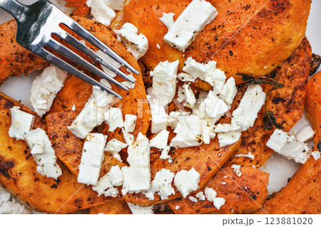 Fork over bright orange grilled butternut squash and white feta cheese Fork over bright orange grilled butternut squash and white feta cheese 123881020