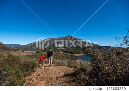 Father and son hiking with scenic mountain view and clear blue sky, La Concepcion reservoir in 123883230