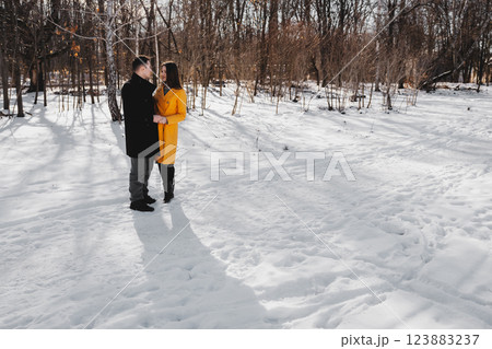 Couple enjoying a winter day in a snowy forest setting with vibrant colors Couple enjoying a winter day in a snowy forest setting with vibrant colors 123883237