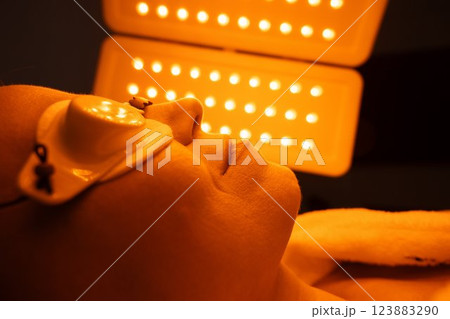 Relaxing session under orange light therapy for skin rejuvenation 123883290