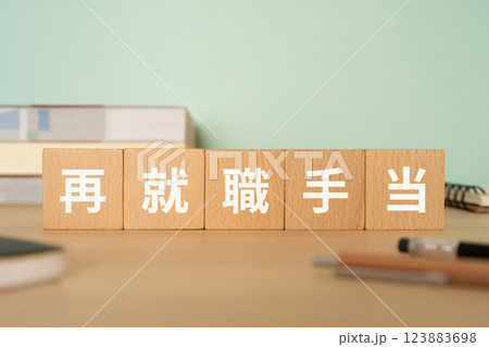 再就職手当の文字が入ったブロックが置かれたデスク 再就職手当の文字が入ったブロックが置かれたデスク 123883698