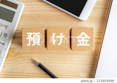 預け金と書かれたブロック、電卓、スマホ 123883699